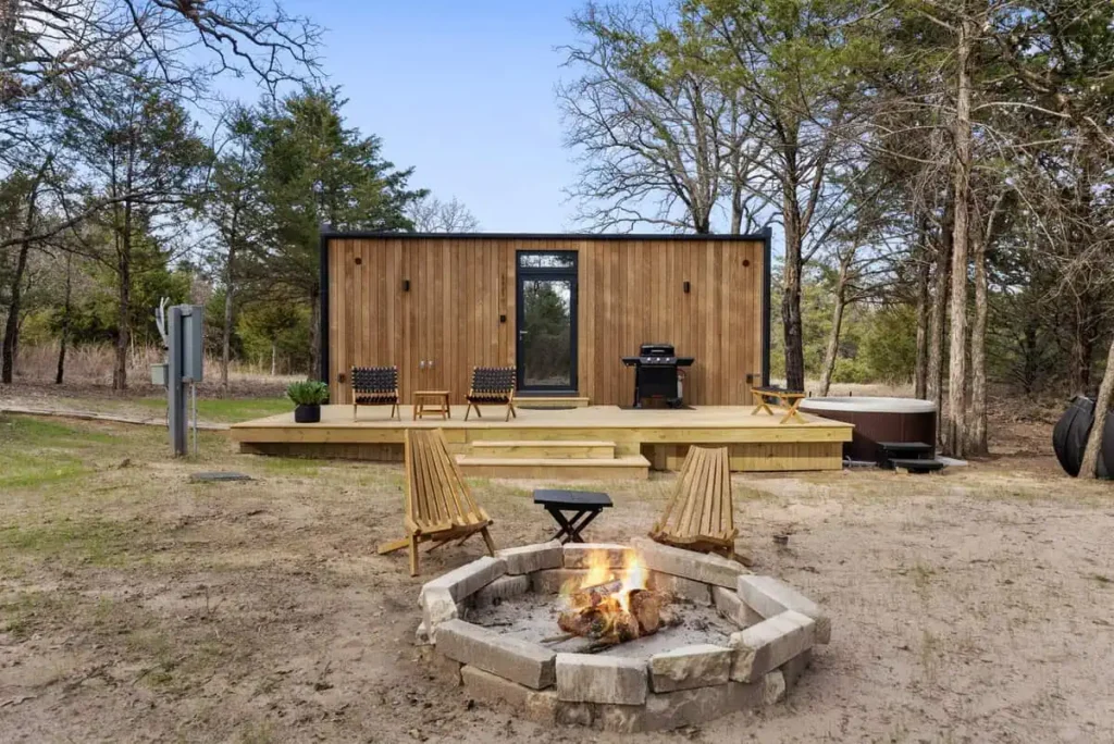 Music Box yurt accommodation at All Is Well Resort featuring a fire pit, outdoor seating, hot tub, and natural surroundings.